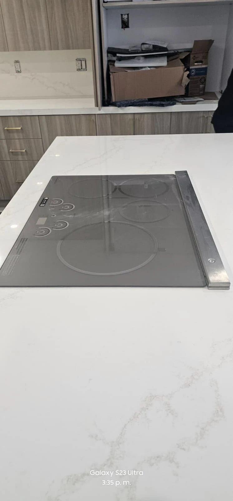Detalle de isla de cuarzo blanco con parrilla eléctrica