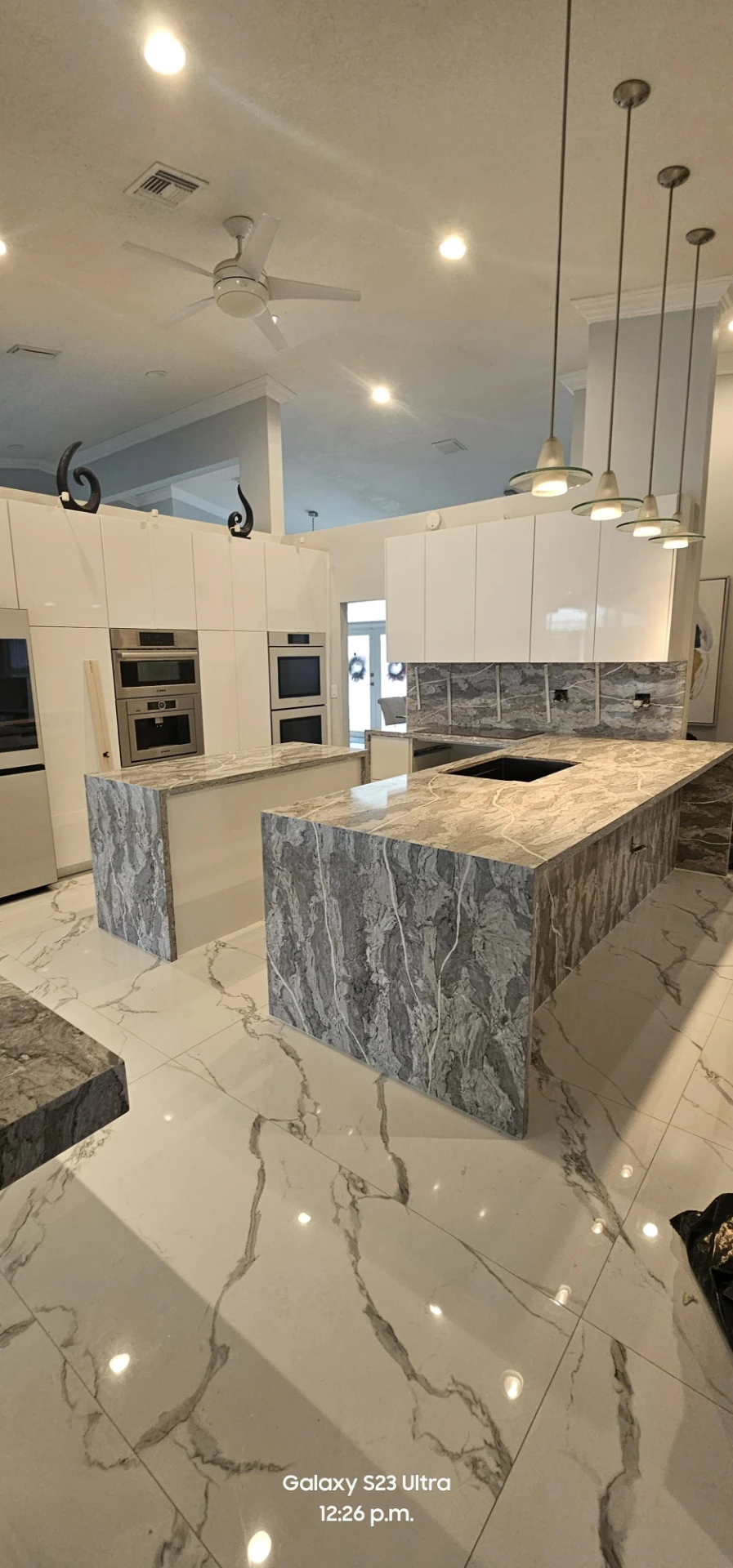Cocina blanca con doble isla en cuarzo veteado