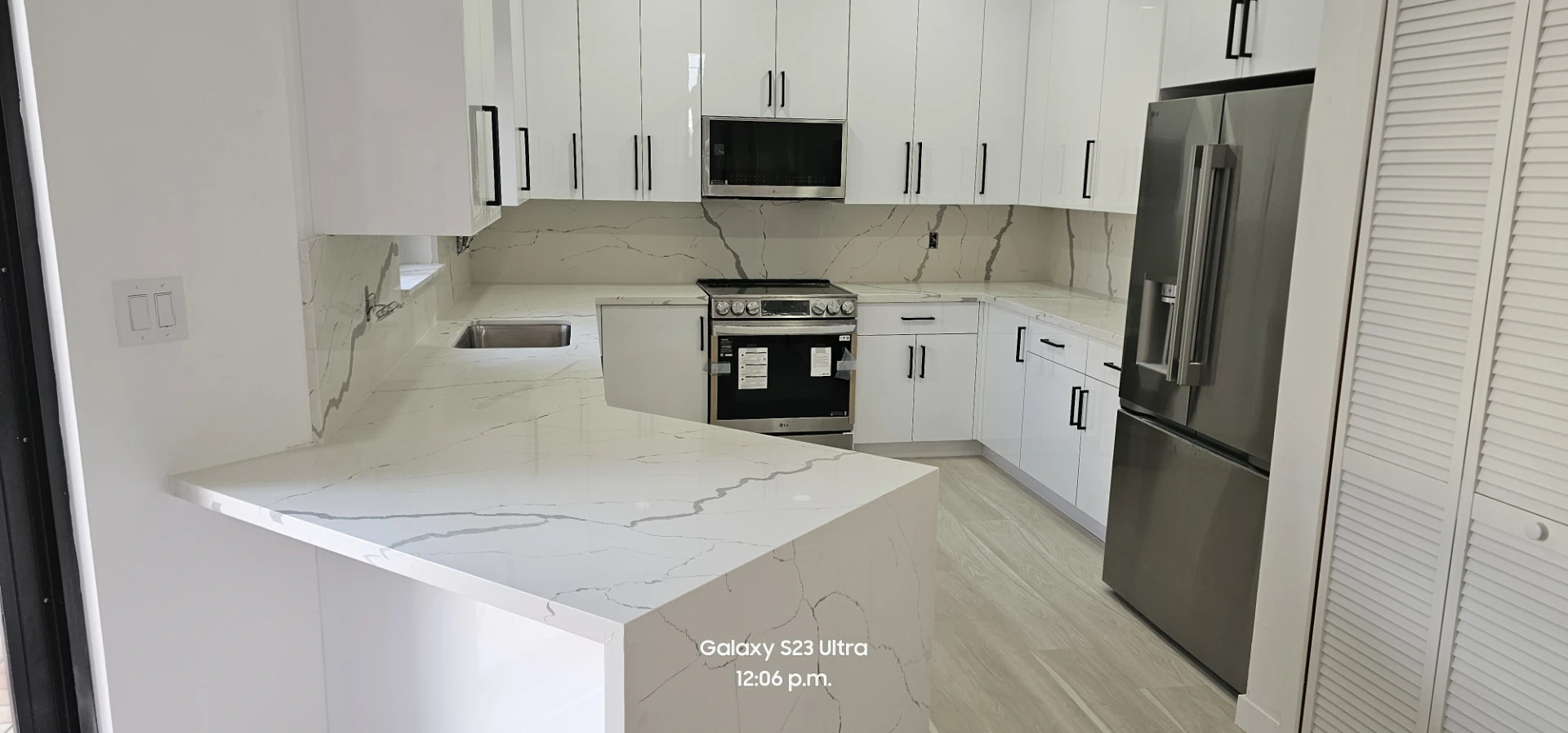 Cocina en U con cubierta y salpicadero de cuarzo calacatta